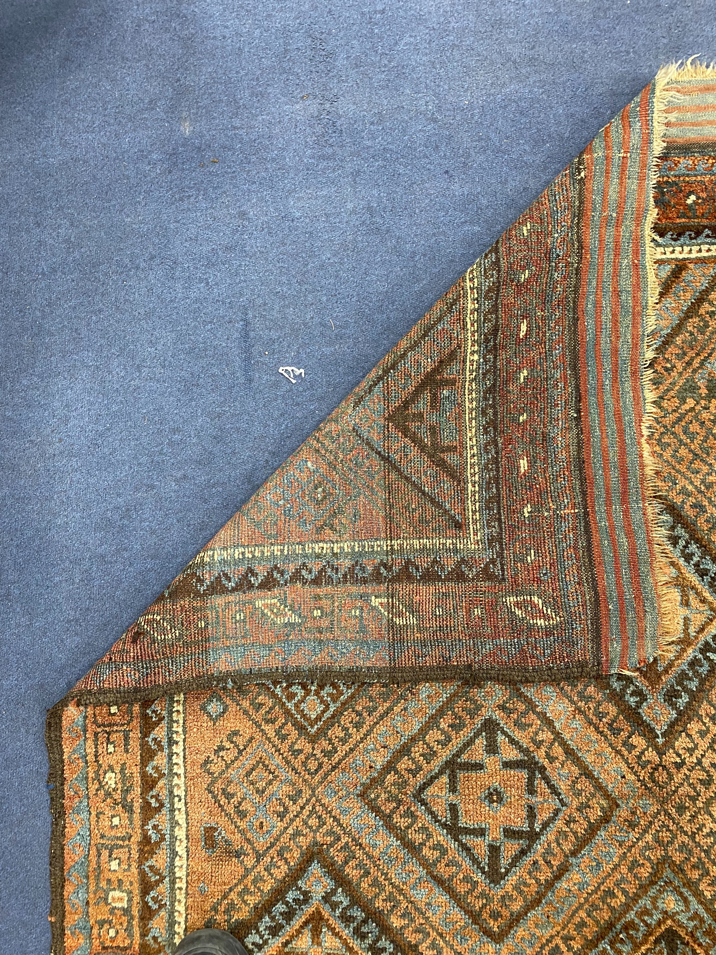 A North West Persian geometric polychrome brick red ground rug, 184 x 96cm